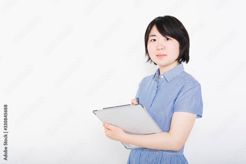 ヒアリングしてチェックするワンピースを着た女性 ヒアリングしてチェックするワンピースを着た女性