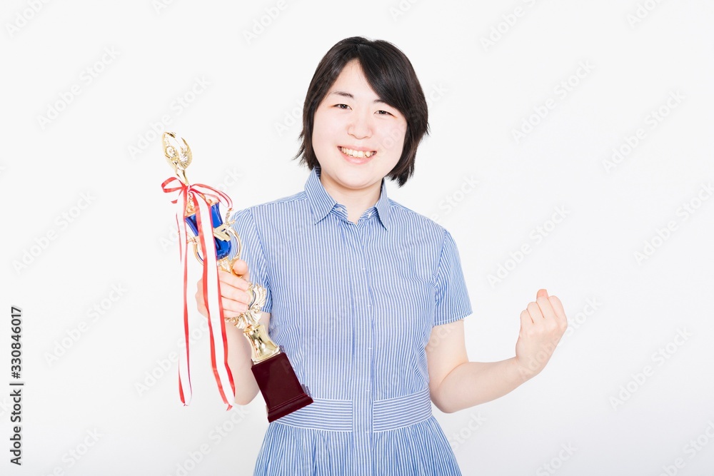 トロフィを持つワンピースを着た女性