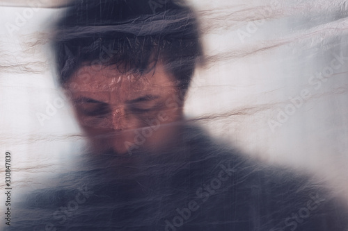 Fotografie Mental health disorder, depressed man behind plastic curtain