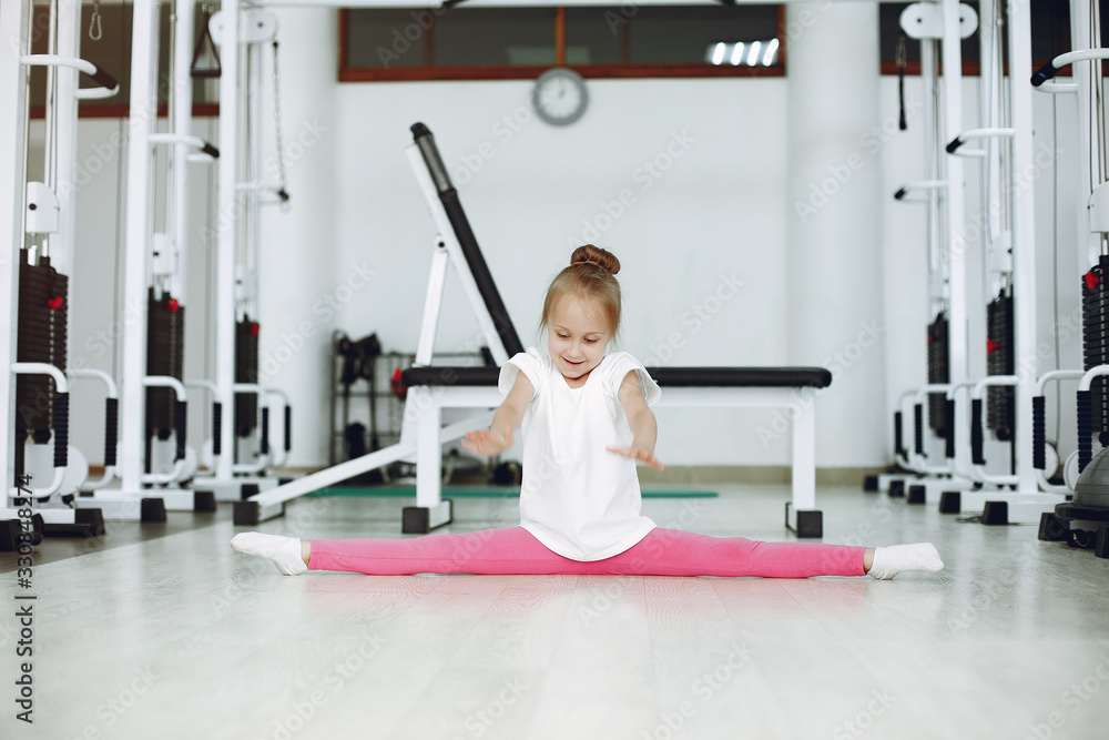 Fototapeta premium Child in a gym. Little girl are engaged in gymnastics