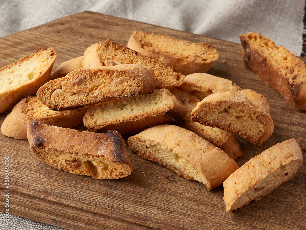 pieces of baked italian christmas biscotti cookies on a brown wooden board