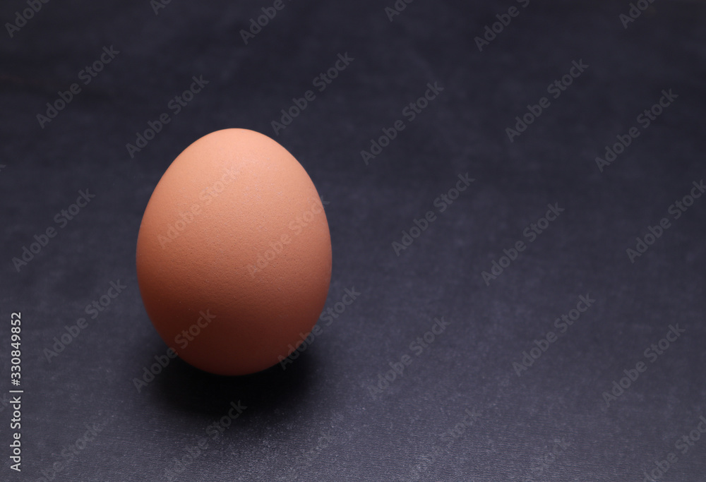 Chicken egg on a black textured background. Chicken egg on a black textured background.