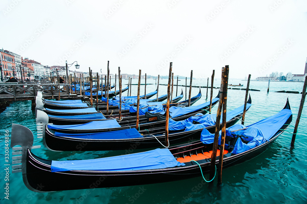 Góndolas de Venecia posicionadas en linea al atardecer