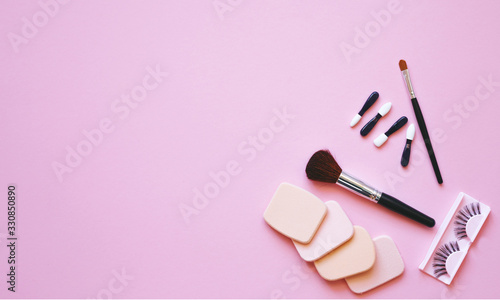 Professional makeup tools. Makeup tools brushes, eyelashes, nail polish, creme ,cotton pads, perfume, applicators on pink background. Cosmetics for beauty.Top view with copy space Flat lay.