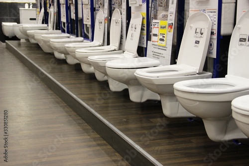 toilets and bidets in the window of a large hypermarket of goods for construction and repair. Construction materials store.