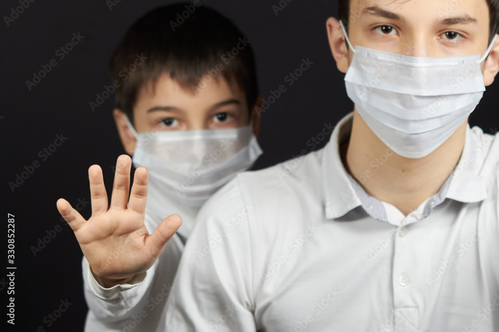 Teenager and boy in a mask in the black background Teenager and boy in a mask in the black background