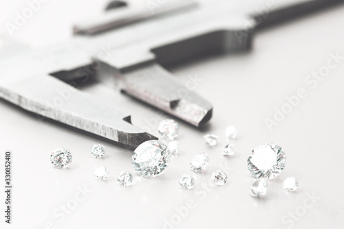 Macro close up of experienced goldsmith sorting high quality diamonds, selecting them to make precious jewels in workshop.Concept of jewelry,luxury,goldsmith, diamonds, brilliance.