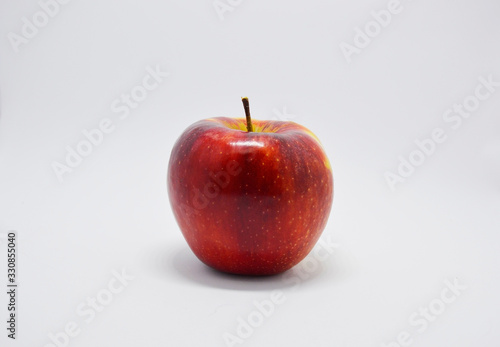 red, bold  juicy apple on a white background. apple is a source of vitamins and iron