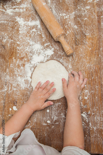Young children make dough products. Hands closeup