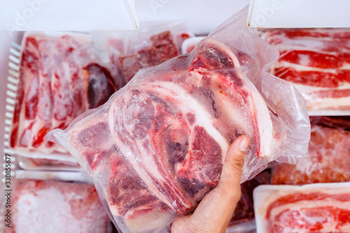 Valokuva Top closeup of hand picking a pile of red meat
