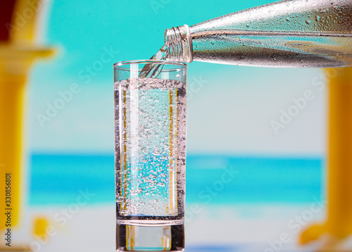 Sparkling mineral water pours from a bottle into a glass