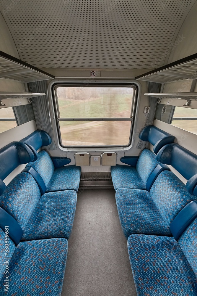 Interior of a passenger train wagon with cabin compartments, empty seats