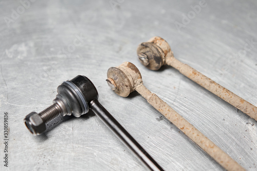 Fotografija New stabilizer bar or link arm ready to replacement into car suspension on metal table in garage for repair and maintenance