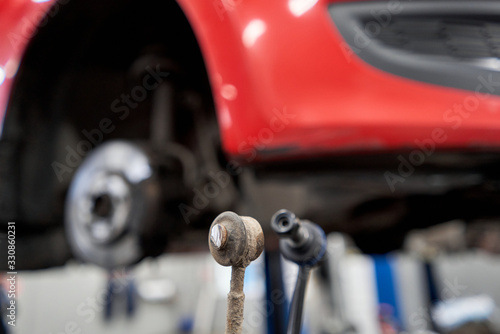Foto New stabilizer bar or link arm ready to replacement into car suspension in garage for repair and maintenance