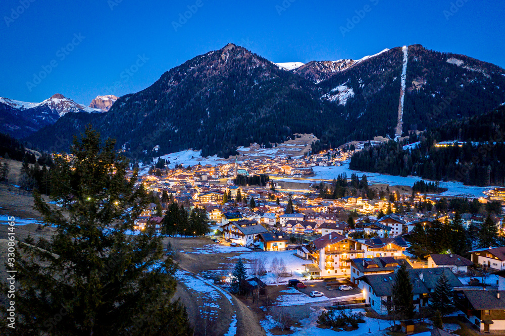 Night aerial view of Pozza di Fassa, a commune in Trentino at the northern Italia. Val di Fassa, Dolomiti