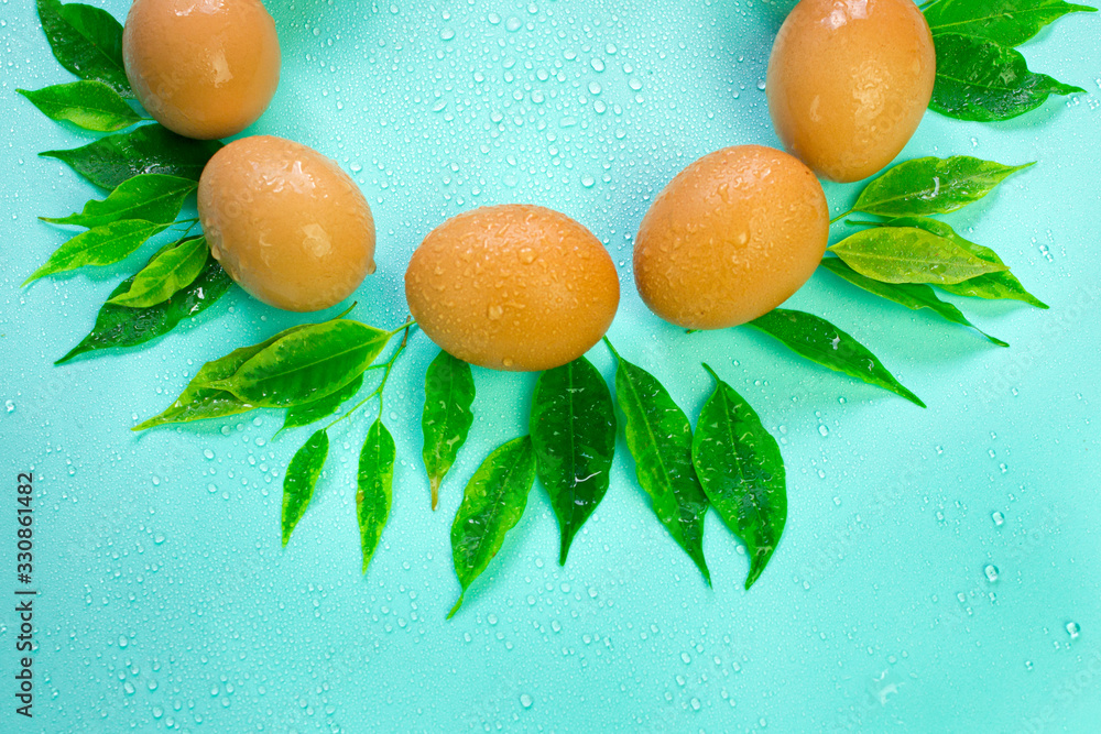 composition of eggs and green leaves for the holy Easter holiday, decorative thematic attributes, vertical photo top view with place for text