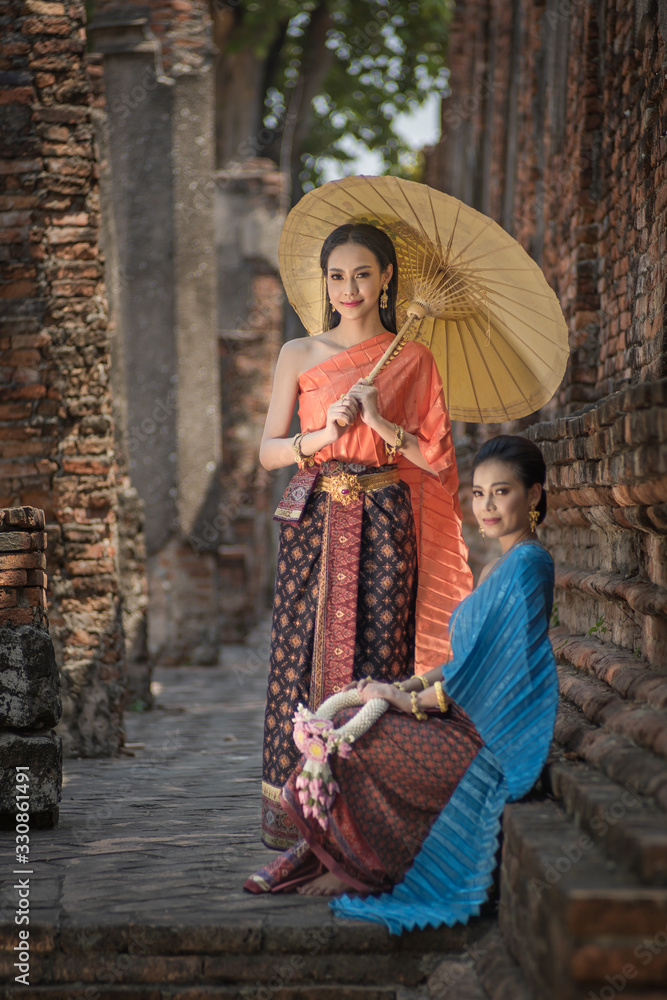 Asian Thai women with umbrella, Pretty girl wearing in Thai traditional dress costume according Thai culture Thailand
