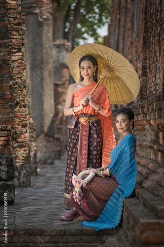 Asian Thai women with umbrella, Pretty girl wearing in Thai traditional dress costume according Thai culture Thailand