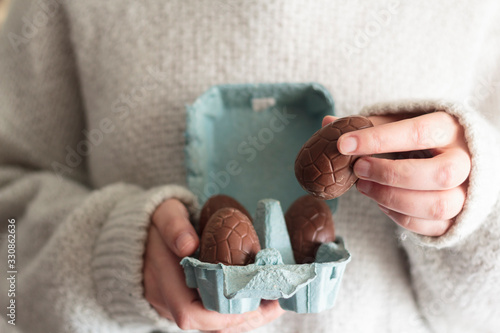 Wall Mural Close up of woman holding easter chocolate egg from egg carton