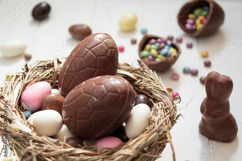 Canvas-taulu Delicious Chocolate eggs and easter almonds on nest, chocolate bunny and sweets