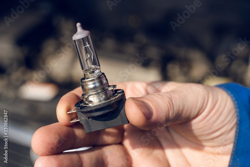 Photos Car service men. Replacing a burnt out lamp in the car headlight