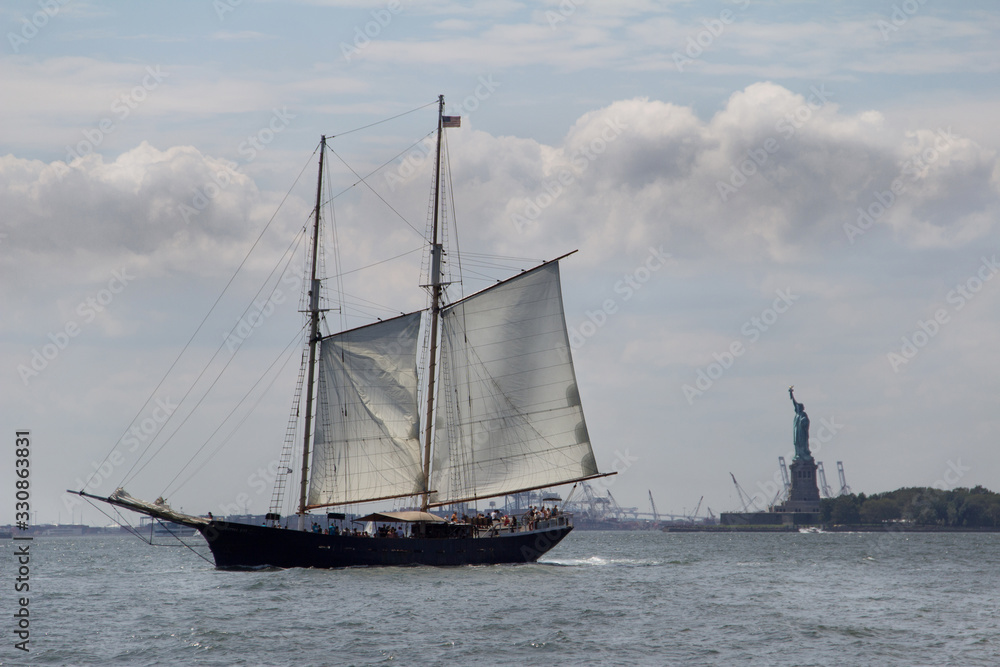Sail boat in Manhattan Bay with Statue of Liberty