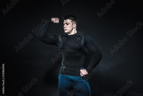 Sexy young athlete posing on a black background in the Studio. Fitness, bodybuilding © Andrii