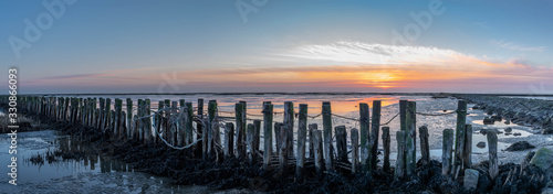  An impressive panorama view of the dike foreland near the imposing Eider barrage, Sunset over the the Wadden Sea, mudflat, tideland on the Northsea Wesselburenerkoog photo