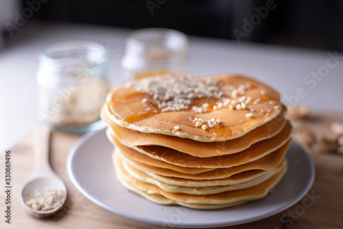 Young female chef in kitchen at home preparing american pancakes. Healthy eating
