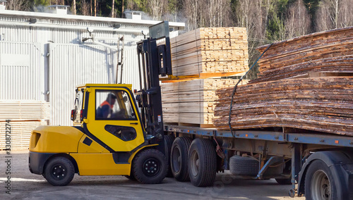 The machine loads the boards, lumber from the finished goods warehouse onto the truck