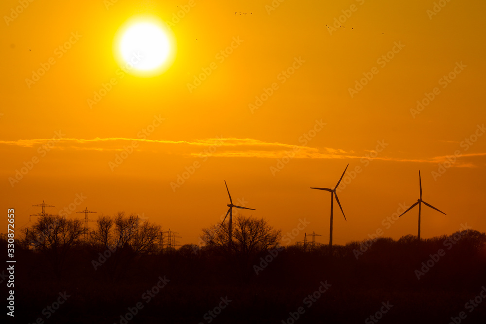 Fototapeta premium Sonnenuntergang mit Windrädern Windkraftanlagen