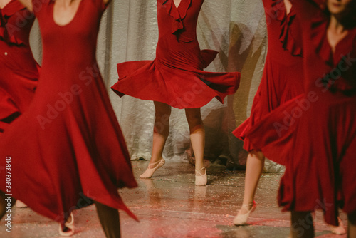 dancers with sensual red dresses dance together on stage