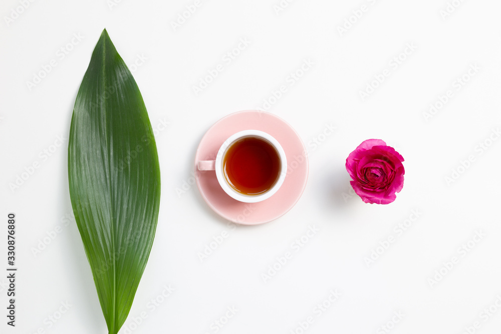 Cup of black tea with green leaf and flower on white background. Flat lay, top view, copy space Cup of black tea with green leaf and flower on white background. Flat lay, top view, copy space