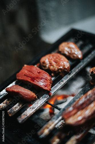 raw meat on a barbecue grill