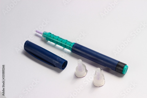 Close Up Photo, Blue and Green Insulin Pen at White Background