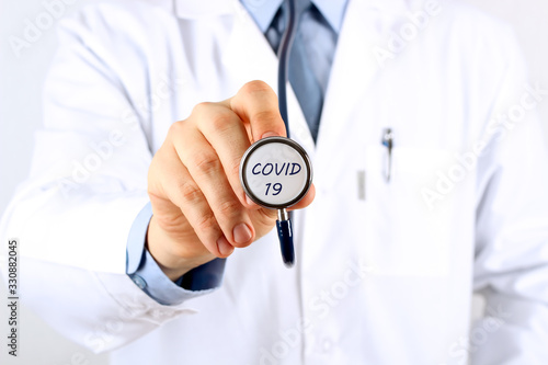 Doctor holding stethoscope with covid 19