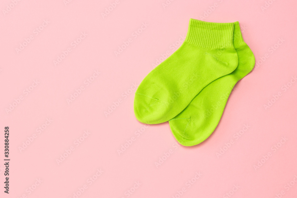 Green sports socks on a pink background. Flat lay. Green sports socks on a pink background. Flat lay.