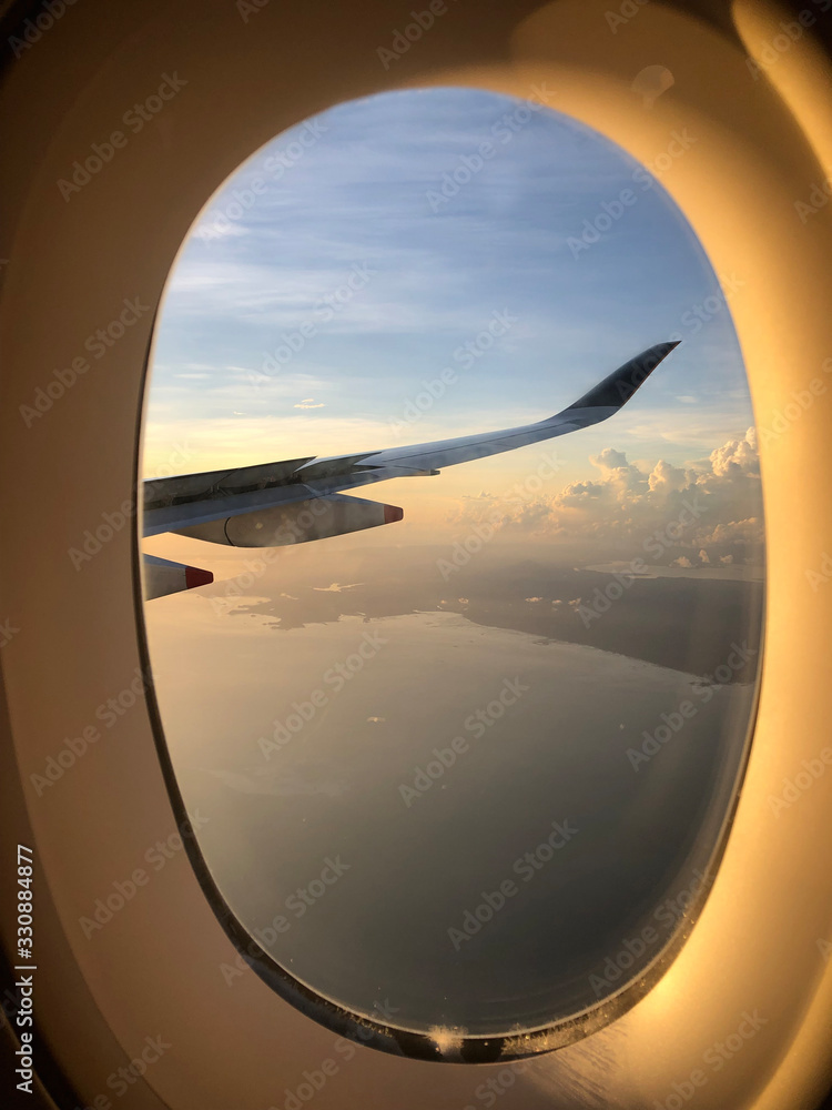 Dramatic cloudscape with the airplane's wing during sunrise from the airplane's window Dramatic cloudscape with the airplane's wing during sunrise from the airplane's window