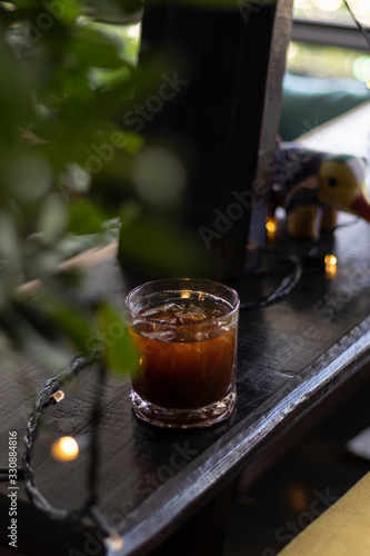 transparent glass of iced black coffee or americano on wooden table