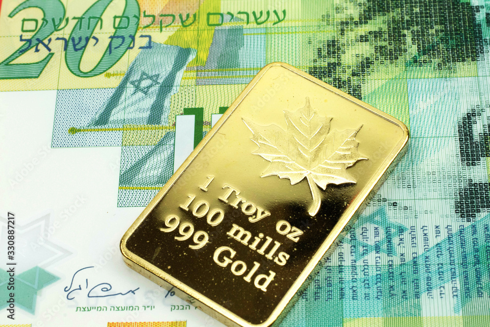A macro image of a green twenty shekel note from Israel with a gold bar. Shot close up. A macro image of a green twenty shekel note from Israel with a gold bar. Shot close up.