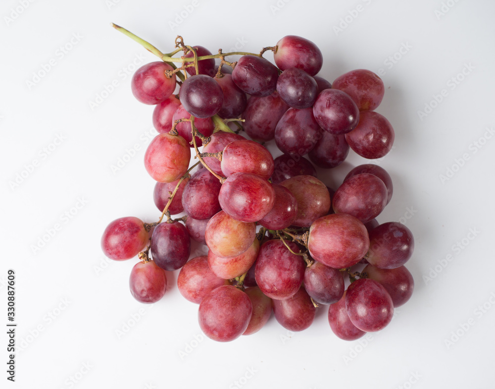 A bunch of pink large grapes on a white background. Studio photography