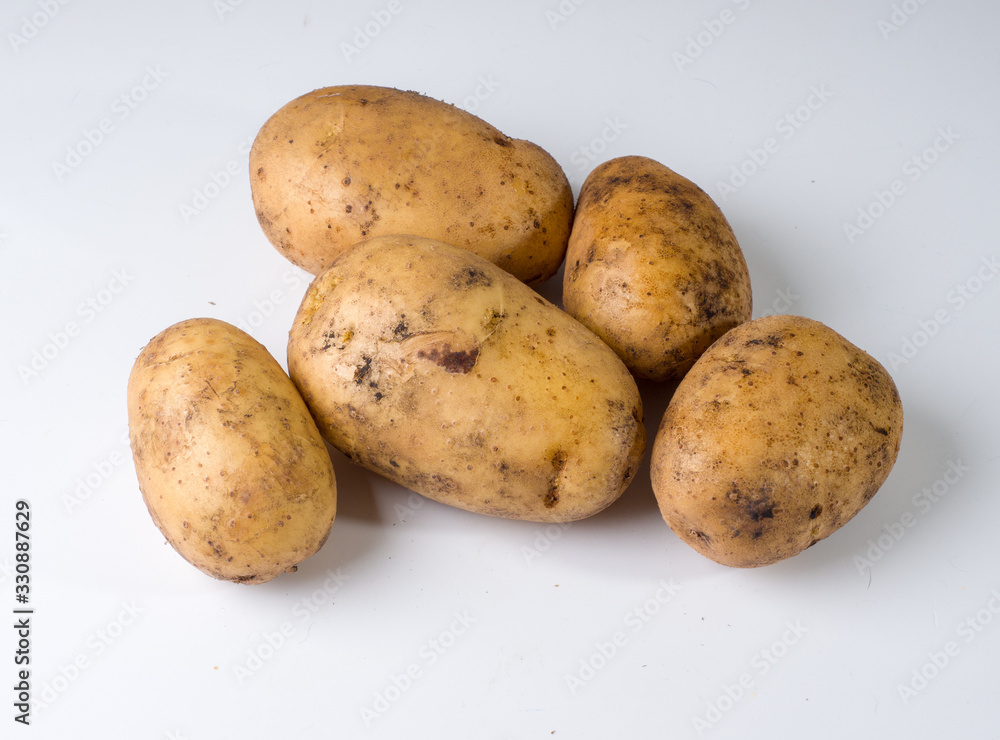 Several potatoes on a white surface. Studio photography Several potatoes on a white surface. Studio photography
