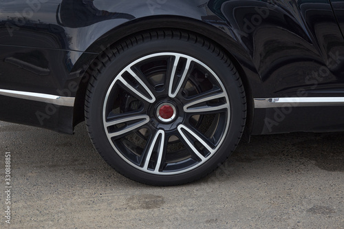 wheel of a black car close up on a sunny day © AleksFil