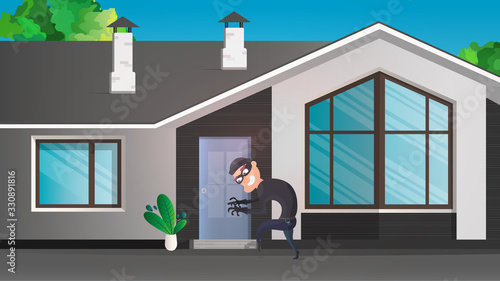 A thief sneaks into the house. The robber is trying to crack the door. Sign of a robbery. A surveillance camera recorded a thief. Security concept. 