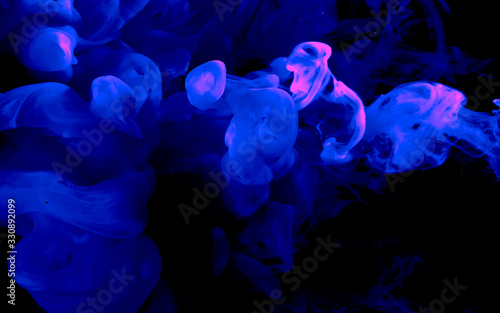 Blue abstract background. Cool trending screensaver. Blue watercolor ink in water on a black background.