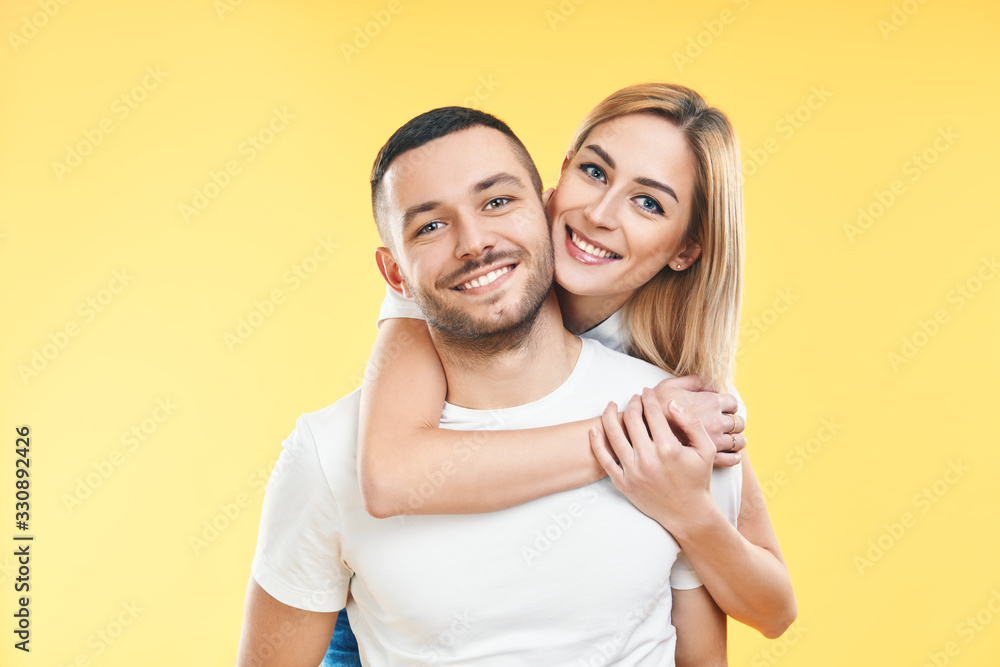 Fototapeta premium Happy smiling couple in love on yellow background