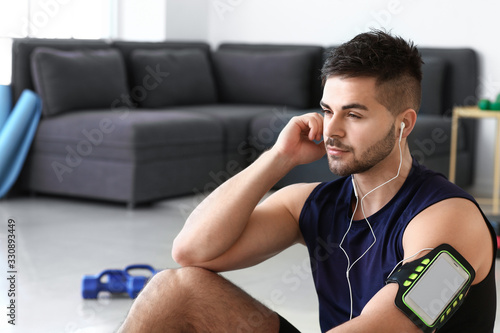Sporty young man listening ...