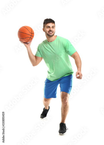 Sporty young man with ball on white background © Pixel-Shot