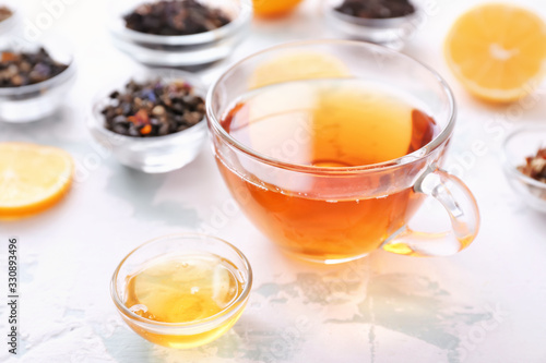 Cup of hot tea with honey on white background