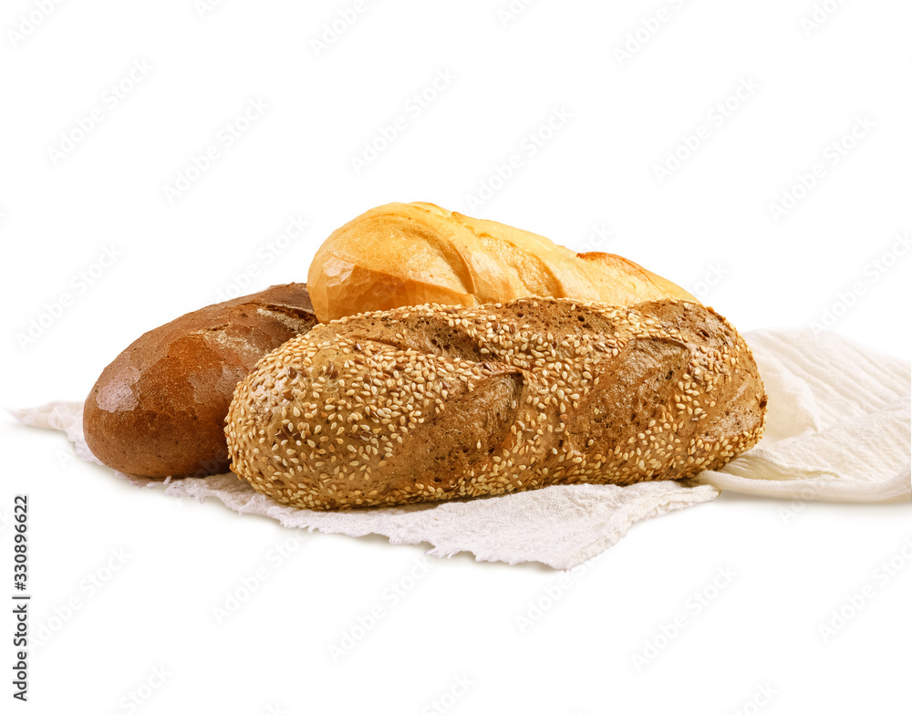Rye bread, a wheat loaf, and a baguette with sesame seeds lying on a white towel. Isolated over white background.